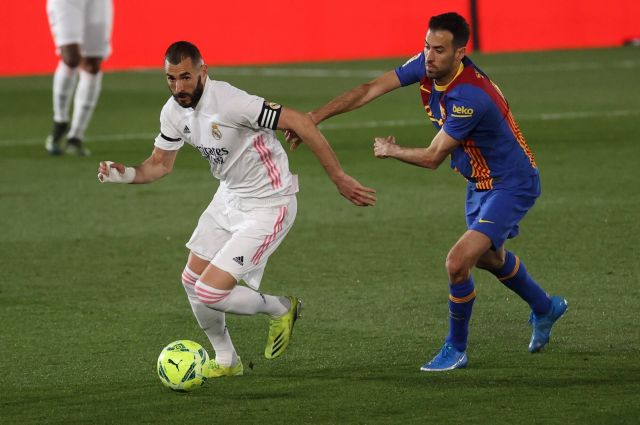 Real Madrid s Karim Benzema (L) in action against FC Barcelona, Barca s Sergio Busquets during a Spanish LaLiga soccer